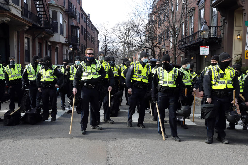 Boston police officers stand in a street in the Beacon Hill neighborhood near the Statehouse, Sunday, Jan. 17, 2021, in Boston. (AP Photo/Michael Dwyer)
