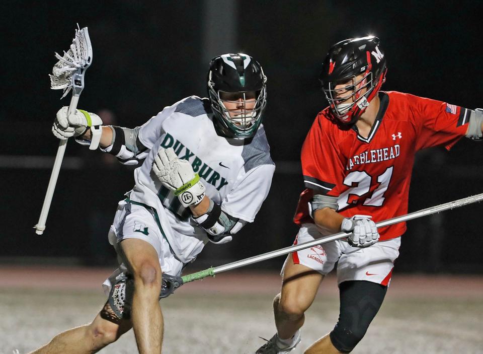 Attacker Colin Hulett fends off a Marblehead player behind their net.Duxbury battle Marblehead lacrosse in MIAA semi finals tournament action in Weymouth on Wednesday June 14, 2023 