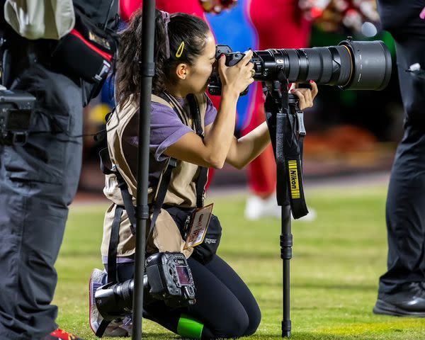 <p>Nick Tre. Smith/AP</p> Emily Curiel photographing a Chiefs vs. Broncos game