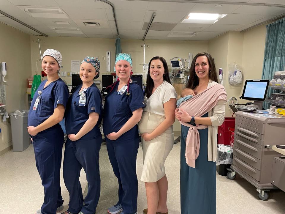 Four of the 11 pregnant staff at Wentworth-Douglass Hospital pose with their colleague, Serena Swanson and her newborn, Everett.