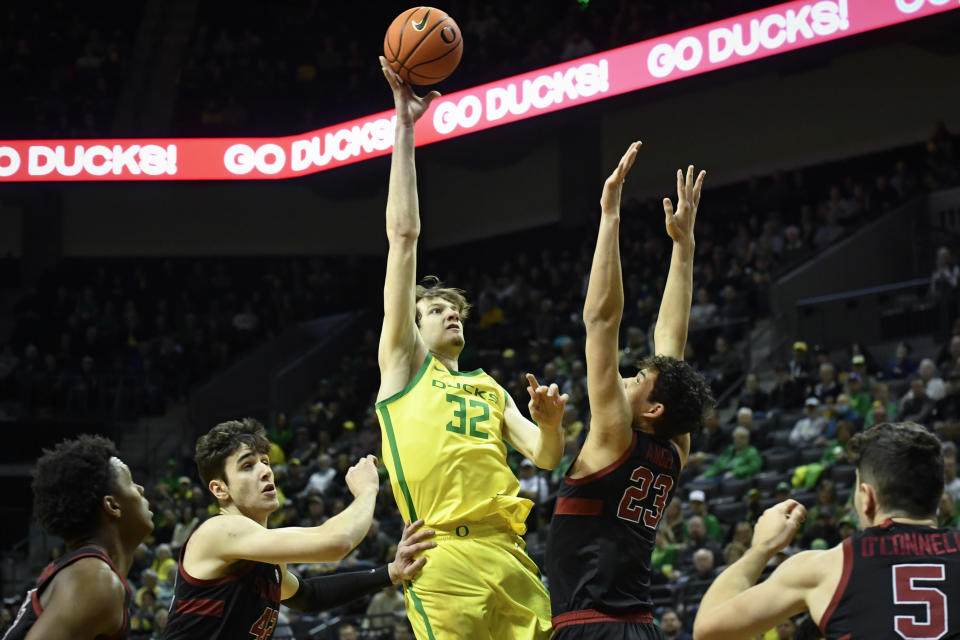 Oregon center Nate Bittle (32) shoots over Stanford forward Maxime Raynaud, second from left, and forward Brandon Angel (23) during the first half of an NCAA college basketball game Saturday, March 4, 2023, in Eugene, Ore. (AP Photo/Andy Nelson)