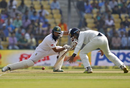 South Africa's captain Hashim Amla (L) plays a shot as India's Cheteshwar Pujara watches during the third day of their third test cricket match in Nagpur, India, November 27, 2015. REUTERS/Amit Dave