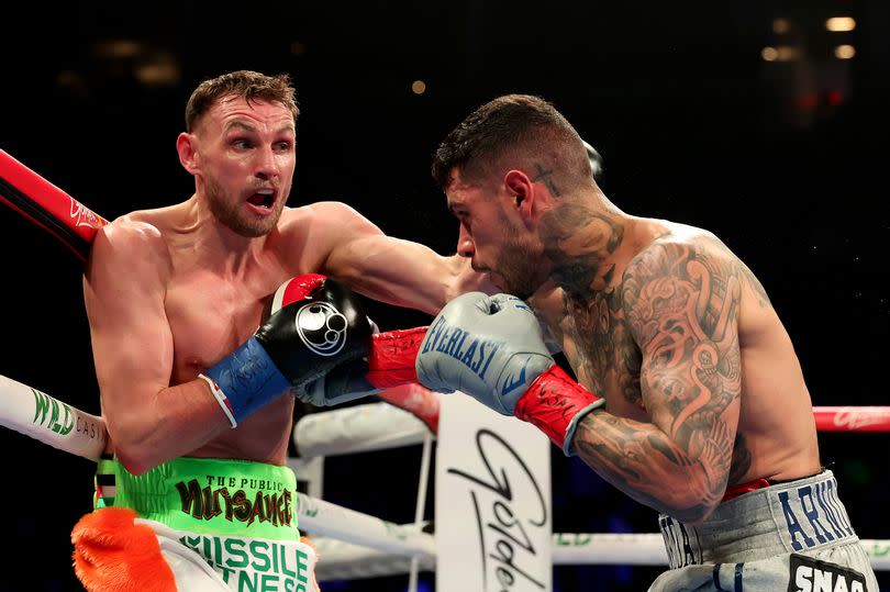 Photo shows Sean McComb exchanging blows with Arnold Barboza Jr