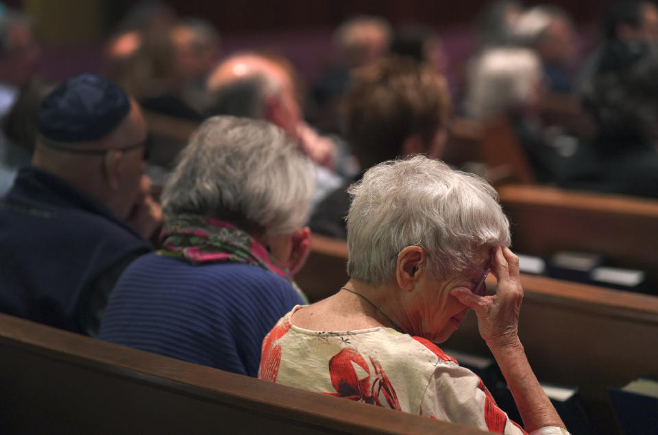 Anne Faigen, right, says a silent prayer for her friends in Israel while at a Shabbat service at Temple Sinai in Pittsburgh on Friday, Oct. 13, 2023. (AP Photo/Jessie Wardarski)