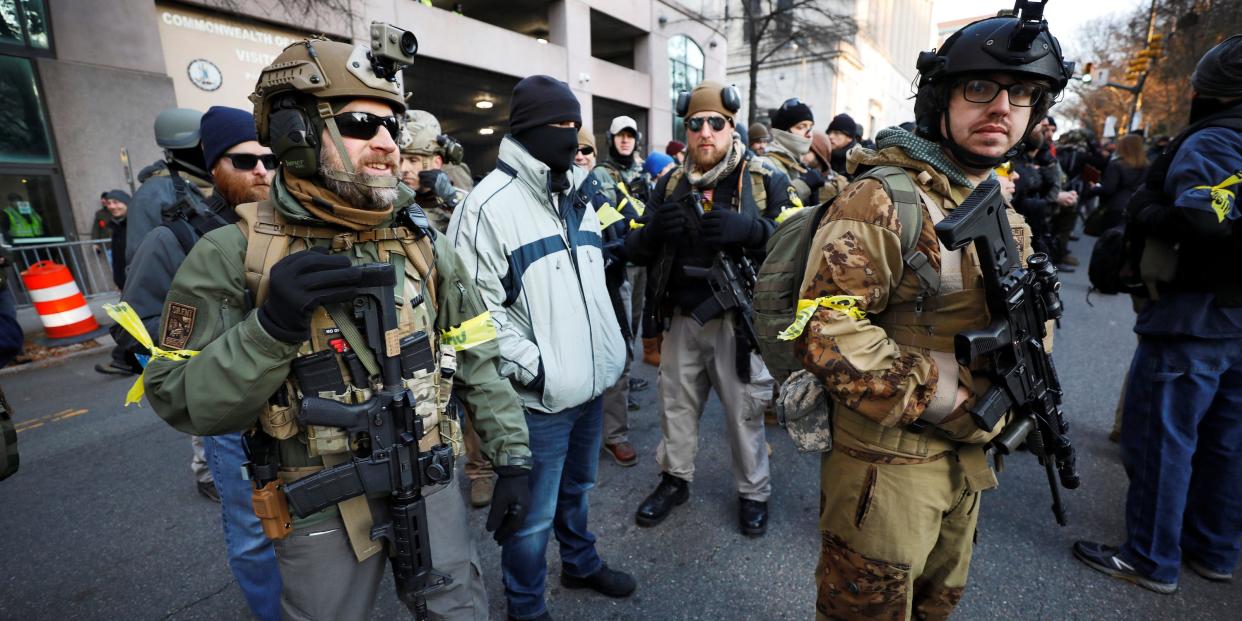 Armed militia members stand guard outside a no-gun zone at a rally by gun rights advocates and militia members near Virginia's Capitol, in Richmond, Virginia