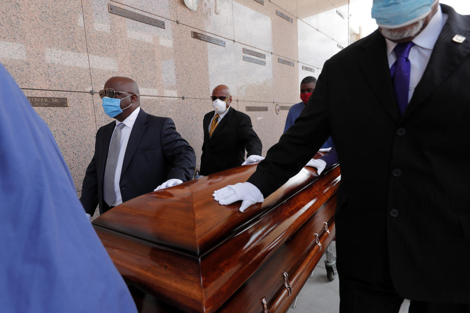 FILE - In this April 22, 2020, file photo, pallbearers, who were among only 10 allowed mourners, walk the casket for internment at the funeral for Larry Hammond, who died from the coronavirus, at Mount Olivet Cemetery in New Orleans. Government health officials say Native Americans, Latinos and Black people are two to three times more likely than whites to die of COVID-19. (AP Photo/Gerald Herbert, File)