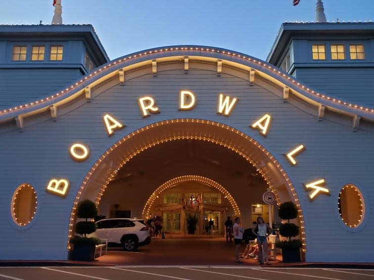 exterior shot of the sign in front of disney's boardwalk inn resort lit up at night