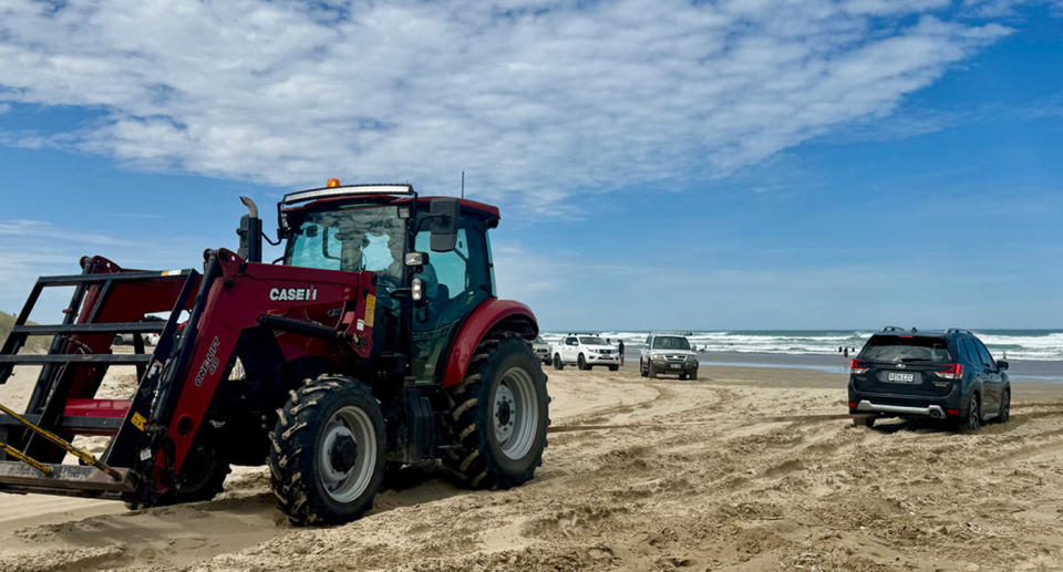 A tractor pulls a bogged AWD vehicle off Goolwa beach. 