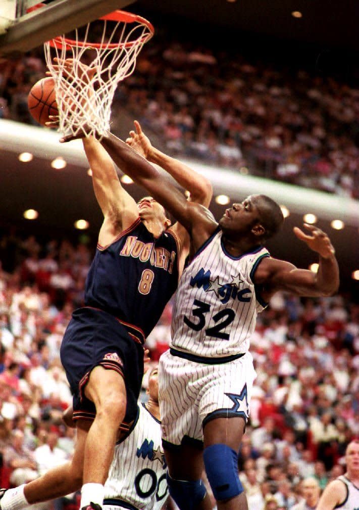Denver Nuggets forward Brian Williams is fouled by Shaquille O'Neal of the Orlando Magic as Williams tries for a basket during the first period of their 08 March 1994 game. O'Neal scored 29 points as the Magic went on to win the game 95-88. (TONY RANZE/AFP/Getty Images)