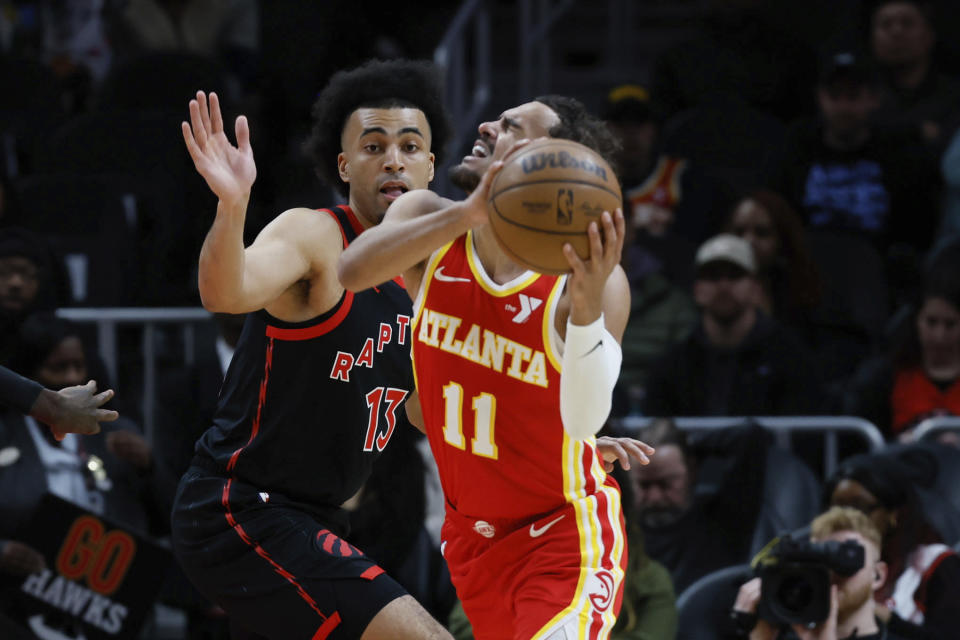 Atlanta Hawks guard Trae Young (11) is fouled by Toronto Raptors forward Jordan Nwora (13) during the first half of an NBA basketball game Sunday, Jan. 28, 2024, in Atlanta. (Miguel Martinez/Atlanta Journal-Constitution via AP)