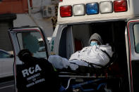Trabajadores del servicio de emergencias suben un paciente a una ambulancia a las puertas del Hospital Brooklyn Center. (Foto: Andrew Kelly / Reuters).