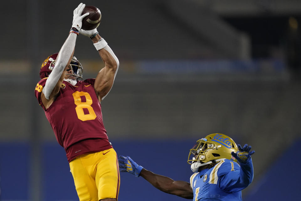 Southern California wide receiver Amon-Ra St. Brown, left, catches a pass while defended by UCLA defensive back Jay Shaw during the first quarter of an NCAA college football game Saturday, Dec 12, 2020, in Pasadena, Calif. (AP Photo/Ashley Landis)