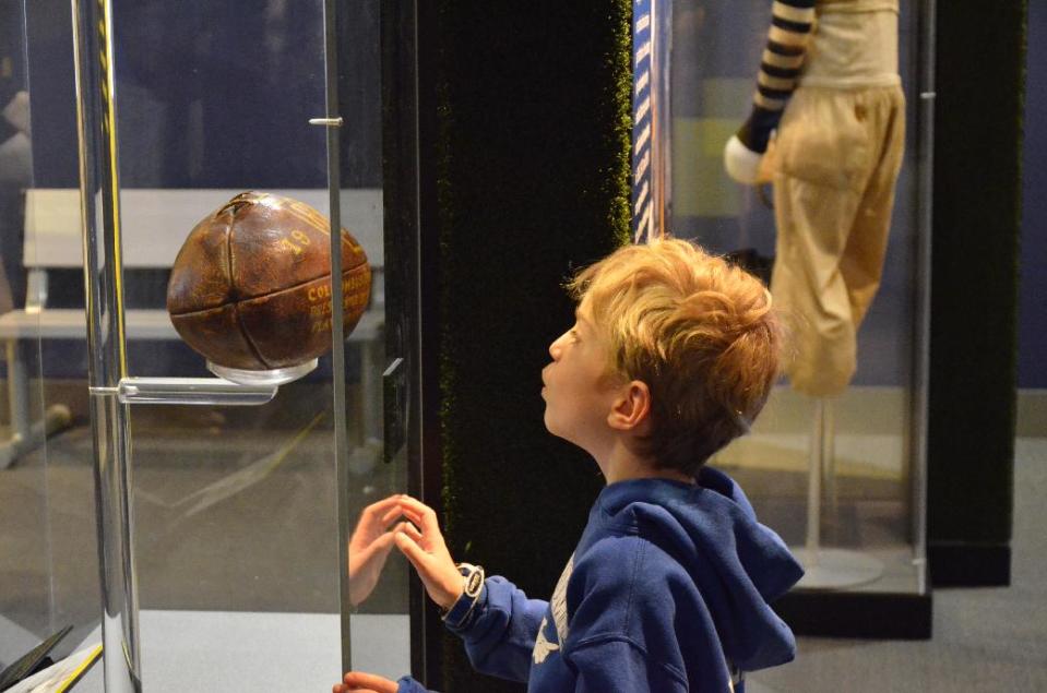 This undated image provided by Liberty Science Center shows a young visitor at the museum looking at an artifact from an exhibit called “Gridiron Glory.” The Liberty Science Center is one of a number of places for Super Bowl fans to visit in New Jersey while in town for the championship game. (AP Photo/Liberty Science Center) (AP Photo/Liberty Science Center)