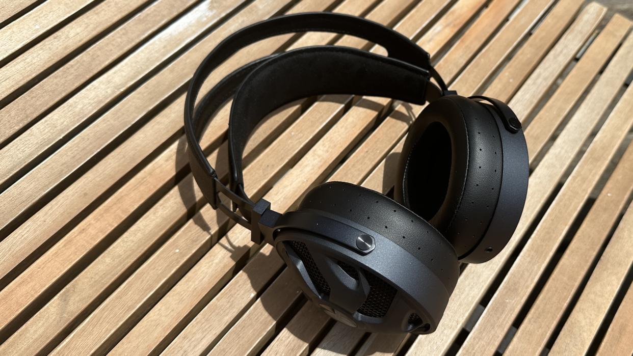  The FiiO FT3 over-ear headphones in black on a wooden surface. 