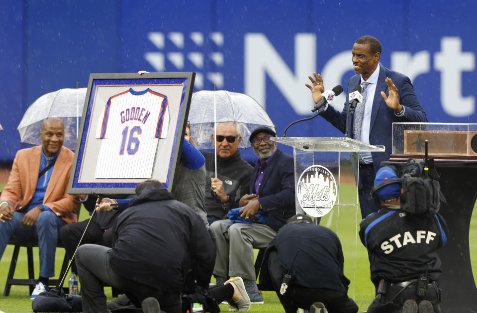 Former New York Mets pitcher Dwight Gooden, top right, acknowledges fans during a ceremony to retire his number at Citi Field before a baseball game between the Mets and the Kansas City Royals, Sunday, April 14, 2024, in New York. (AP Photo/Noah K. Murray)