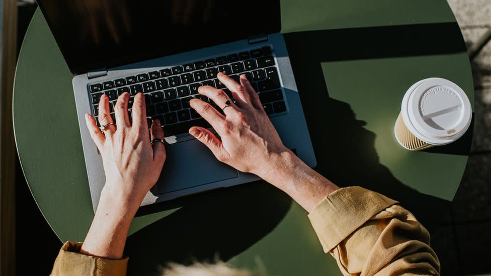 A person types on a laptop