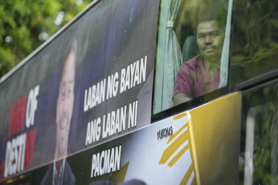 Retired Filipino boxing hero and senator Manny Pacquiao looks from his vehicle before filing his certificate of candidacy for next year's presidential elections at the Commission on Elections on Friday, Oct. 1, 2021 in Manila, Philippines. Friday marks the first day of a week-long period when politicians can file their certificates of candidacy for the May 9, 2022 national elections where Filipinos will get to vote for their next president, vice president, and other national and local officials.(AP Photo/Aaron Favila)