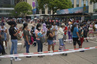 In this Saturday, May 1, 2021, photo, domestic helpers from the Philippines line up at the temporary testing center for COVID-19, in Hong Kong. Hong Kong officials have dropped a plan to make it mandatory for foreign domestic workers to be vaccinated against the coronavirus, after the move drew criticism that it was discriminatory. (AP Photo/Kin Cheung)