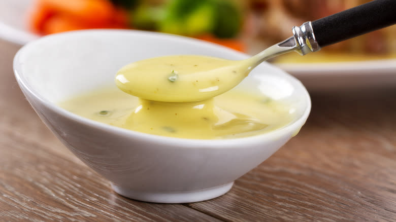 spooning béarnaise sauce from bowl