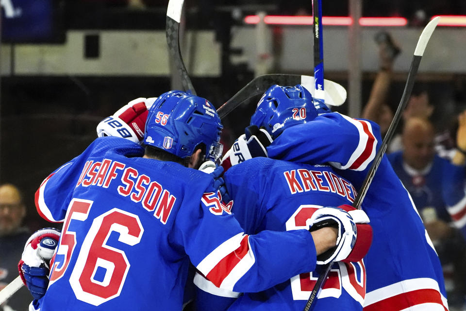 New York Rangers defenseman Erik Gustafsson (56), left wing Jimmy Vesey and others celebrate center Vincent Trocheck's goal against the Carolina Hurricanes during the first period in Game 1 of an NHL hockey Stanley Cup second-round playoff series, Sunday, May 5, 2024, in New York. (AP Photo/Julia Nikhinson)