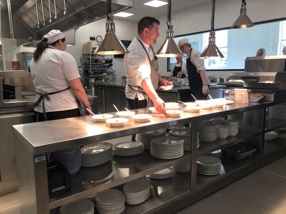 Martin Kester, supervisor of Sussex County Community College's culinary and hospitality program, puts out dishes for the public to sample during the grand opening of the college's Culinary Institute on Main Street in Newton Thursday, April 27, 2023.