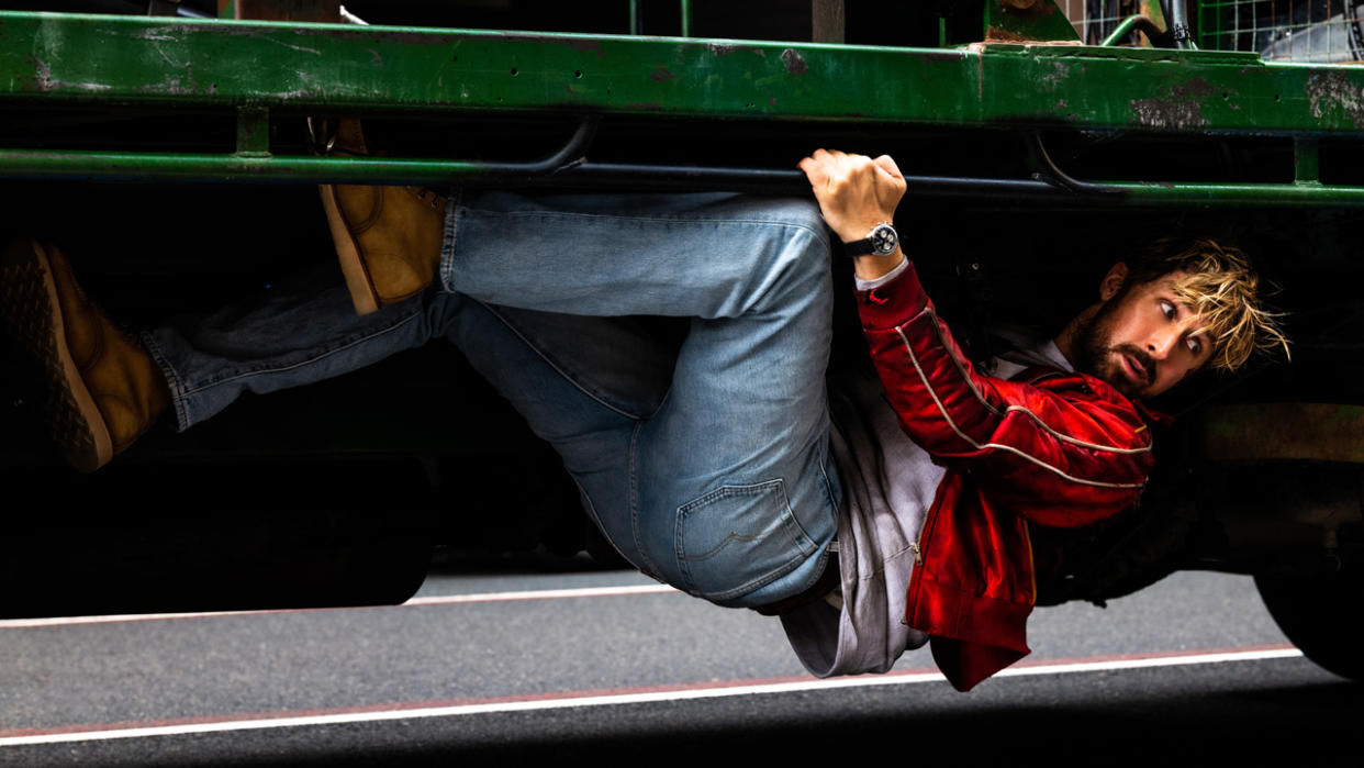  Ryan Gosling hanging on under a truck in The Fall Guy. 