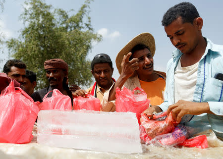 Hussein Abdu, 40, the father of ten-year-old malnourished girl Afaf Hussein, buys ice at a market near the village of al-Jaraib in the northwestern province of Hajjah, Yemen, February 20, 2019. People who don't have refrigerators to freeze water, buy ice to have access to cold drinking water in extremely hot temperatures. REUTERS/Khaled Abdullah