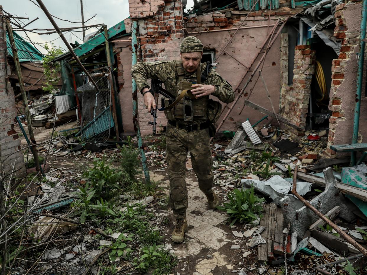 A Ukrainian serviceman walks among debris (EPA)