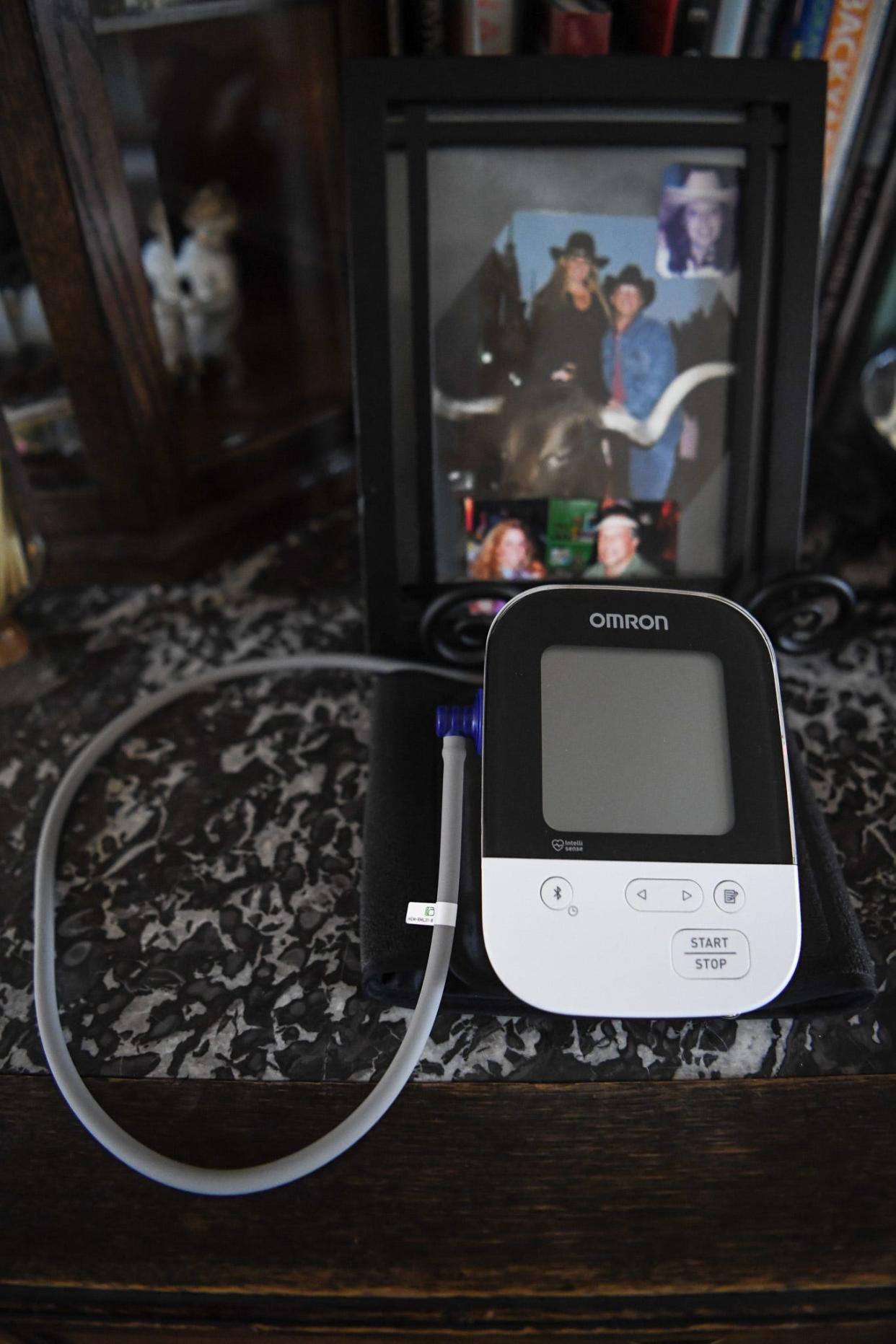 Sandy Edlein's blood pressure monitor sits at the ready alongside family photographs.