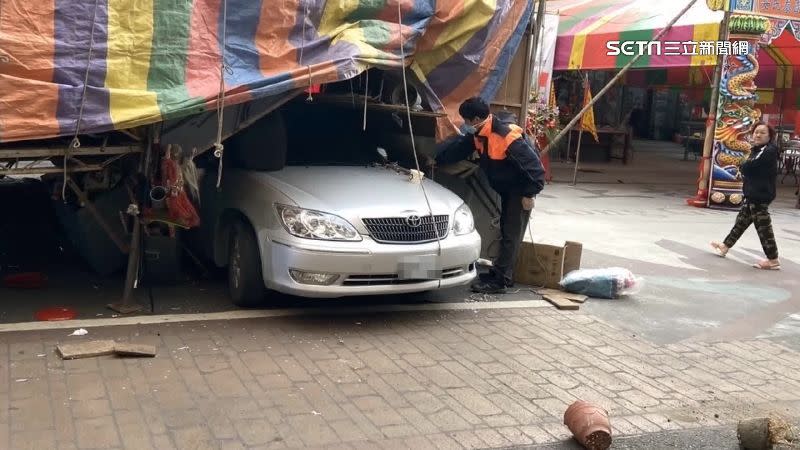 戲棚支架變形壓在轎車車頂。