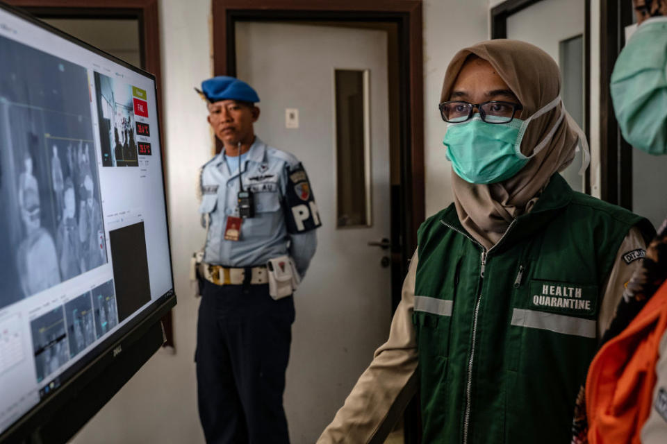 An Indonesian health official monitors as passengers from an international flight pass a thermal scanner upon arrival at the Adisucipto International Airport in Yogyakarta, Indonesia on Jan. 23, 2020. | Ulet Ifansasti—Getty Images