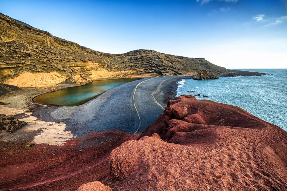 Volcanic black sand meets an algae-green lagoon at Charco de Los Clicos (Getty Images/iStockphoto)