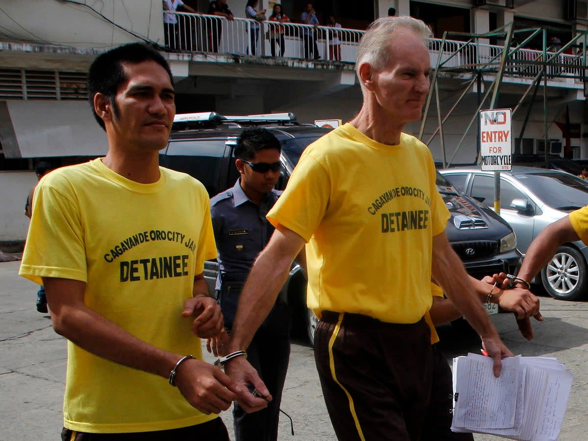 File. Peter Scully  of Australia (R), accused of raping and trafficking two girls in the Philippines, leaves the court handcuffed to another inmate (L) after his arraignment in Cagayan de Oro City, on the southern Philippine island of Mindanao on June 16, 2015 (AFP via Getty Images)