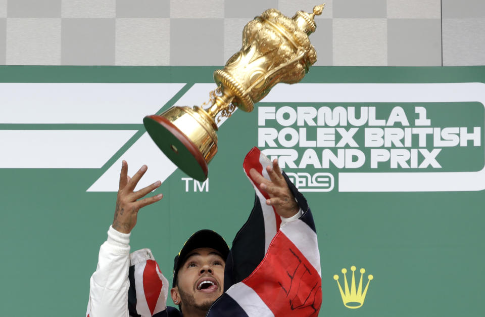 Mercedes driver Lewis Hamilton of Britain celebrates on the podium after winning the British Formula One Grand Prix at the Silverstone racetrack, Silverstone, England, Sunday, July 14, 2019. (AP Photo/Luca Bruno)