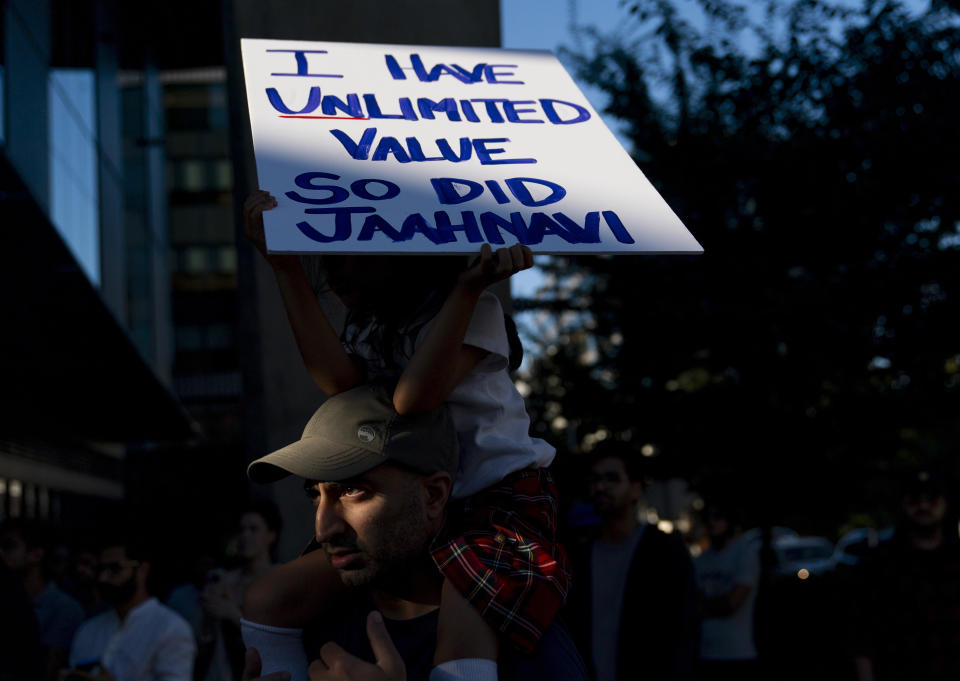 Layla Allibhai, 5, sits atop father Mo Allibhai's shoulders while holding a sign for Jaahnavi Kandula, a 23-year-old woman hit and killed in January by officer Kevin Dave in a police cruiser, as people protest after body camera footage was released of a Seattle police officer joking about Kandula's death, Thursday, Sept. 14, 2023, in Seattle. (AP Photo/Lindsey Wasson)