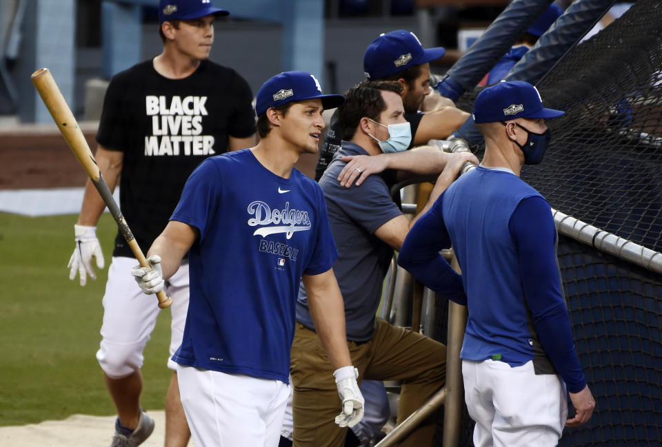 Los Angeles Dodgers' Corey Seager, left, looks on during batting practice, Tuesday, Sept. 29, 2020, at Dodger Stadium in Los Angeles, ahead of Wednesday's Game 1 of a National League wild-card baseball series against the Milwaukee Brewers. (AP Photo/Chris Pizzello)