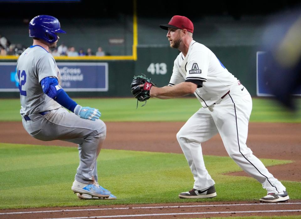 Arizona Diamondbacks pitcher Merrill Kelly tags out Chicago Cubs’ Ian Happ (42) during the fifth inning at Chase Field in Phoenix on April 15, 2024. All players are wearing number 42 in honor of Jackie Robinson Day.