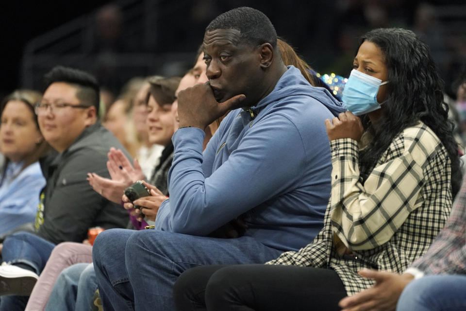 FILE - Former Seattle SuperSonics forward Shawn Kemp, center, attends a WNBA basketball game between the Seattle Storm and the Chicago Sky on May 18, 2022, in Seattle. Prosecutors in Washington state charged Kemp on Friday, April 14, 2023, with first-degree assault in a parking lot shooting last month over a stolen cell phone, noting that in a text message just before the shooting, Kemp wrote, "I'm about to shoot this (expletive)." (AP Photo/Ted S. Warren, File)