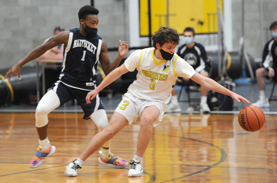 Guarded by Nantucket's Justin Bloise, left, Nauset's Andrew Berardi reaches for the ball during a double-overtime game won by Nauset.