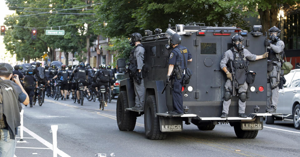 Seattle Police ride on a vehicle behind bicycle police during a Black Lives Matter protest march, Saturday, July 25, 2020, in Seattle. A large group of protesters marched Saturday in Seattle in support of Black Lives Matter and against police brutality and racial injustice. (AP Photo/Ted S. Warren)