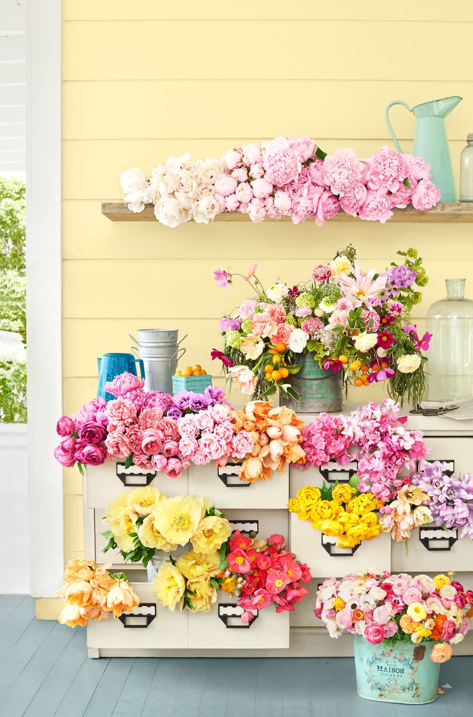 porch loaded up with flowers on a potting table