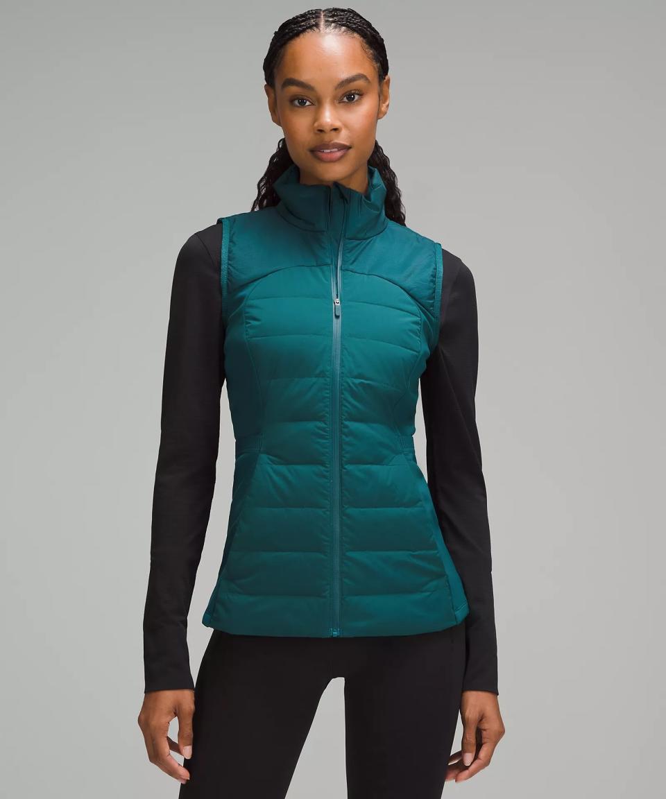 model wearing green running vest with black long sleeve and leggings