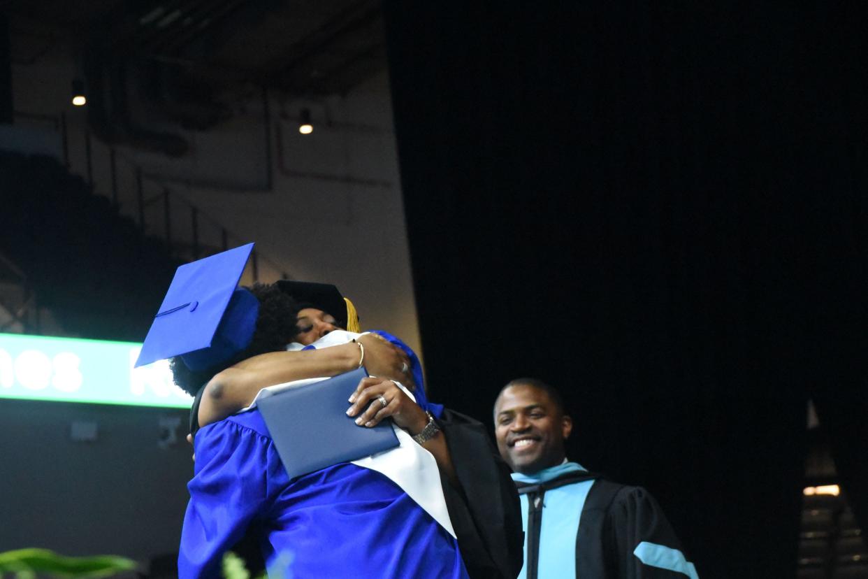 Superintendent Denise Watts embraces her son as she presents him with his diploma.