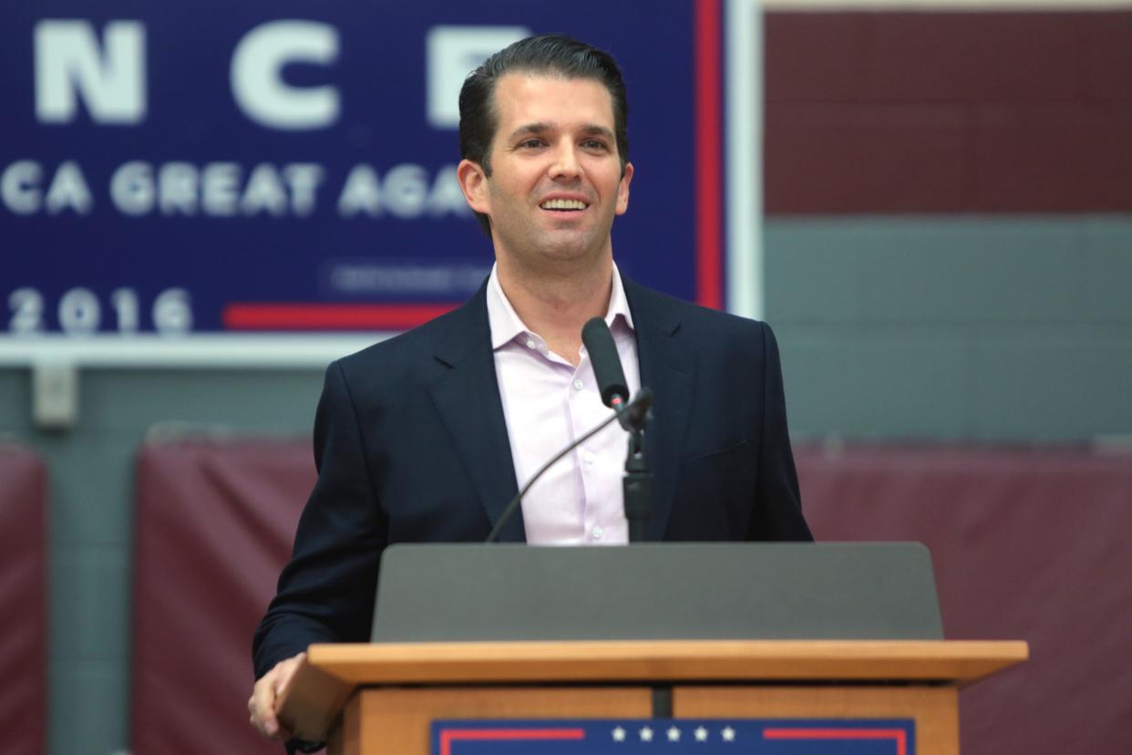 Donald Trump Jr stands at a podium at a Trump 2016 Rally