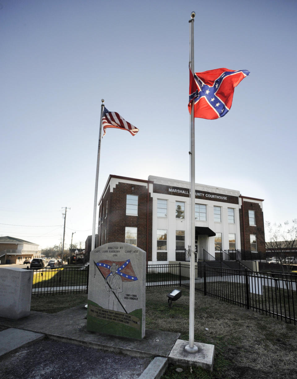 A Confederate monument and rebel battle flag are flown outside the Marshall County Courthouse in Albertville, Ala., on Wednesday, Dec. 9, 2020. Unique Morgan Dunston, a Black woman transformed by leaving the virtually all-white town where she grew up, has been leading demonstrations against the Old South commemoration since August. (AP Photo/Jay Reeves)