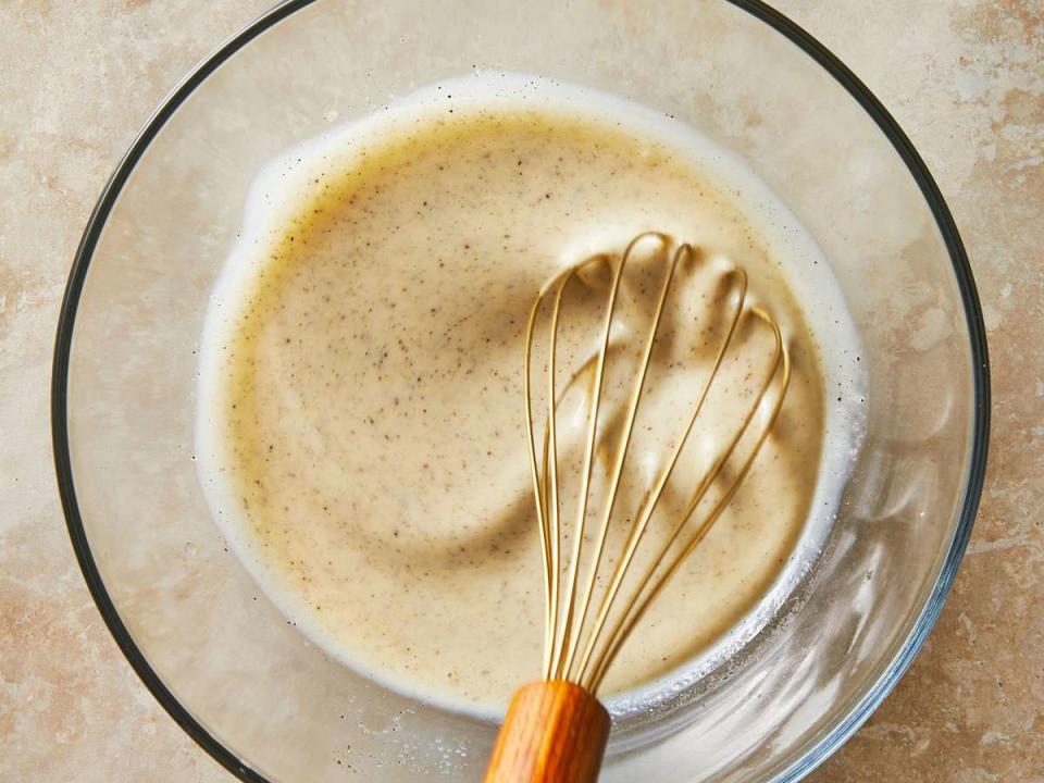 coleslaw dressing in a bowl with a whisk