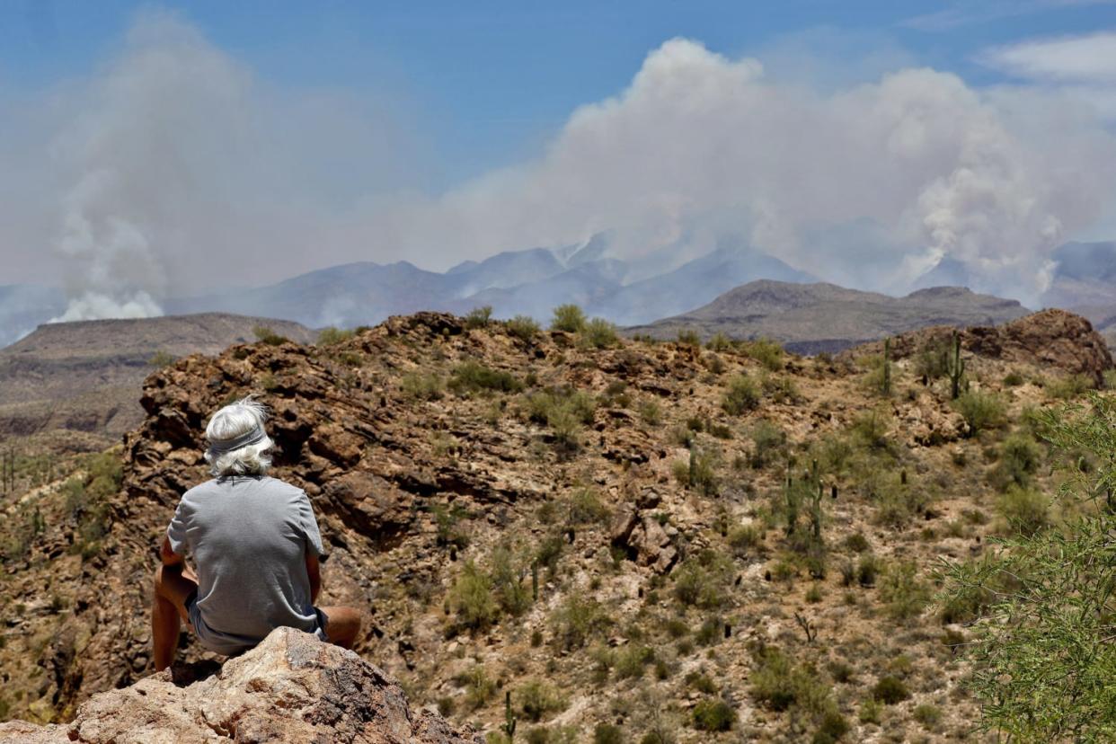 Image: A man watches a portion of the Bush fire burn through the Tonto National Forest from Apache Junction, Ariz. (Matt York / AP)
