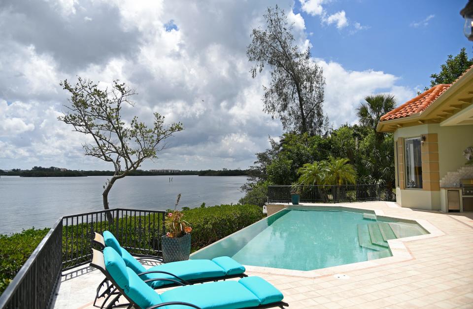 The spacious lanai of the home at 1280 Hidden Harbor Way has a heated saltwater infinity pool overlooking Roberts Bay.
