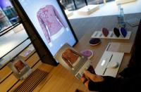 A staff shows the print of a knitting pattern during the measuring process on a computer screen to order the knitting pattern at the Adidas knit for you store in Berlin, Germany March 7, 2017. Picture taken March 7, 2017. REUTERS/Fabrizio Bensch