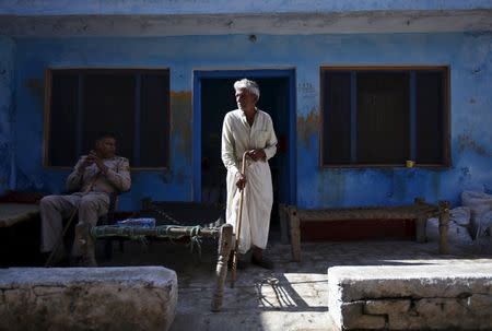 A policeman sits near a relative of Akhalaq Saifi, who was killed by a mob, outside Saifi's house at Bisara village in Uttar Pradesh, India, October 2, 2015. REUTERS/Anindito Mukherjee